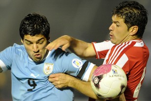 Luis Suárez intenta zafar de la marcación de Iván Píris ante Paraguay.