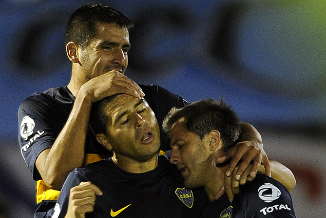 Juan Román Riquelme, tras convertir el gol de penal, recibe los abrazos y felicitaciones Lucas Viatri y Juan Manuel Martínez.