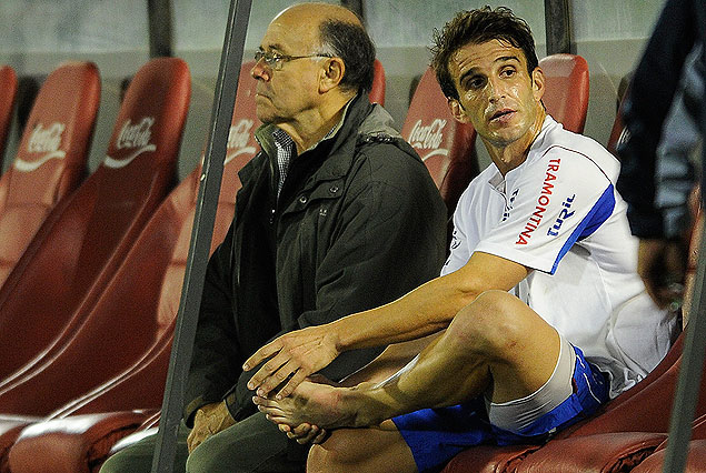Iván Alonso, con su mano sobre la pierna izquierda en el banco junto al Dr. Leonardo Salvarrey.  Sufrió contractura muscular. 