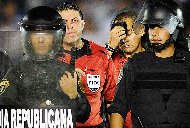 Fernando Falce, de mal arbitraje, acompañado por Igor Moreira, se retira de la cancha custodiado por la policía al finalizar el partido.