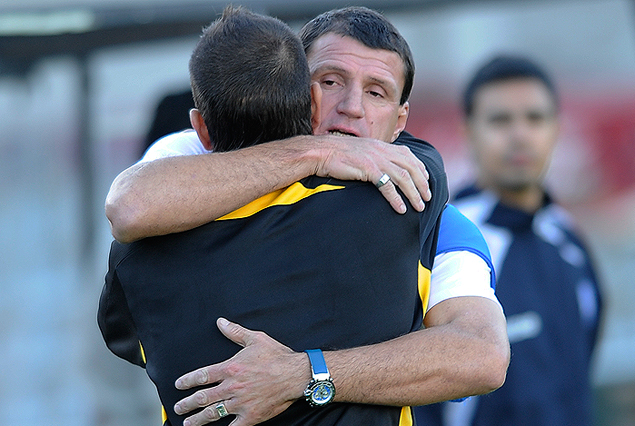 Nelson Olveira, ayudante técnico de Cerro Largo y Antonio Pacheco, capitán aurinegro, en el sentido abrazo de amigos, de dos históricos de Peñarol.