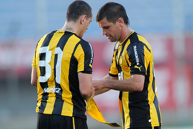 Antonio Pacheco le coloca el brazalete de capitán al "Vasquito" Aguirregaray al dejar la cancha. "No queda otra que seguir trabajando", señaló el capitán aurinegro. 