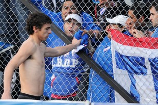 Gonzalo Bueno le regala su camiseta a un hincha.
