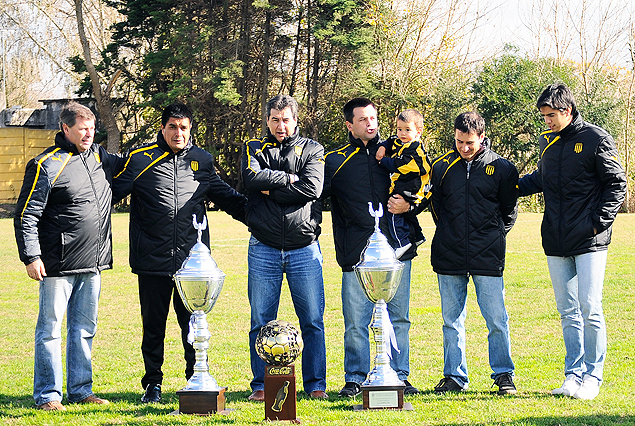 Jorge Da Silva y sus compañeros de cuerpo técnico, posando con el trofeo conquistado por el título de Campeón Uruguayo, este jueves en Los Aromos. "Polilla" se va.
