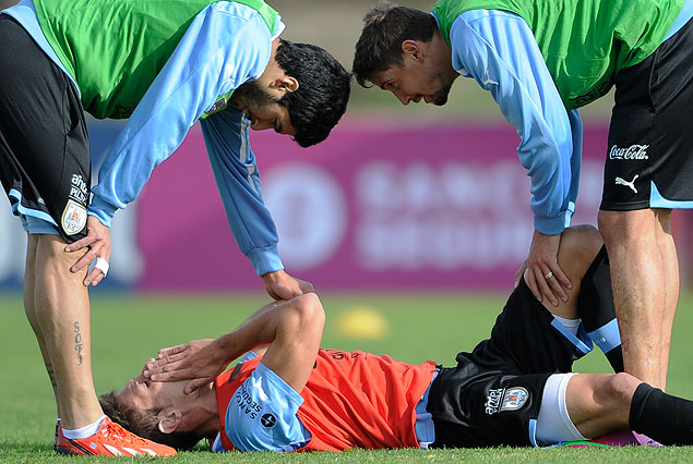 Sebastián Eguren caído por el golpe en la nariz, ayudado por Luis Suárez y Gastón Ramírez en el Complejo "Uruguay Celeste".