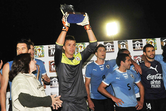 Fernando Muslera le muestra al público, el trofeo obtenido al ser considerado el mejor jugador de la cancha, la réplica de la “Puerta de la Ciudadela”. Le puso candado al arco uruguayo.