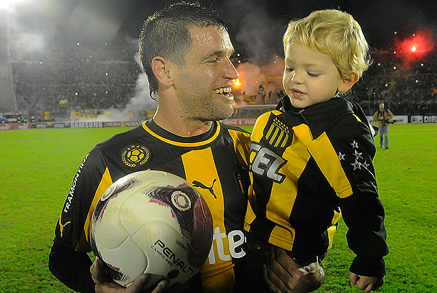 Antonio Pacheco con su hijo Benjamín en brazos y la pelota que se llevó por los tres goles y que seguramente tendrá lugar preponderante en su vitrina.