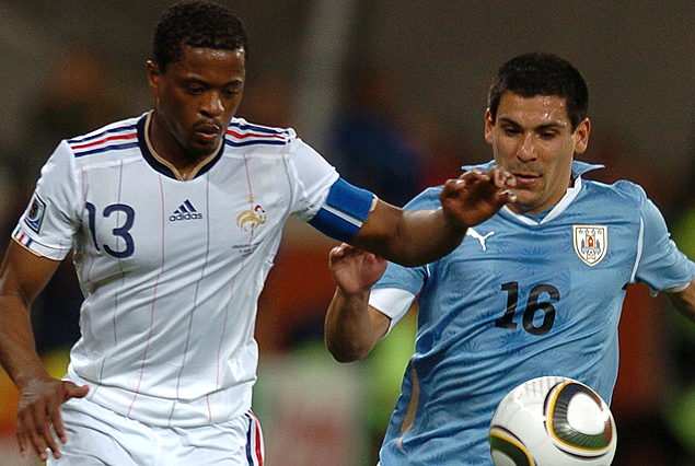 El galo Evra y Maxi Pereira, detrás del balón en el partido de Mundial Sudáfrica 2010.
