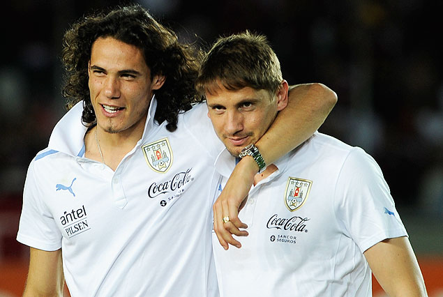 Edinson Cavani y Gastón Ramírez, abrazados caminando por el campo de juego.