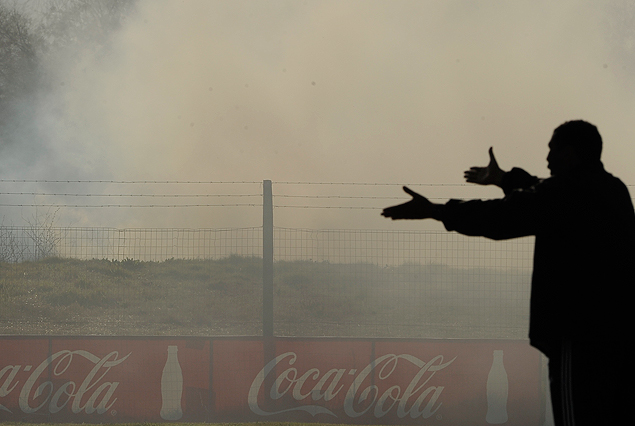 Luis Duarte abre sus brazos hacia el humo que molesta la visual de un arco del Obdulio Varela.