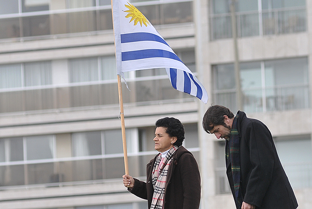 Una pareja con la bandera uruguaya en la explanada municipal