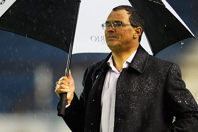Alfredo Arias, DT de Wanderers, bajo un paraguas negro y blanco. La lluvia fue principal protagonista de la noche.