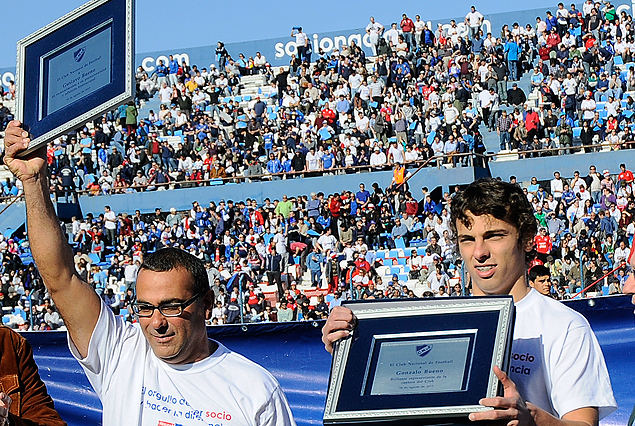 Gustavo y Gonzalo Bueno con las plaquetas que recibieron de la comisión de obras de Los Céspedes. Padre e hijo, viajan en lunes a Rusia.