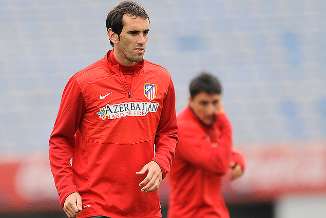 Diego Godín y Cristian "Cebolla" Rodríguez en la cancha del Estadio Centenario. Titulares en filas del Atlético Madrid.