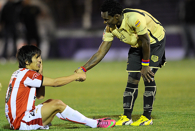 Hamilton Pereira, en el suelo no encuentra consuelo, caballerosamente el colombiano Mosquera le tiende su mano para ayudarlo a reincorporarse. 