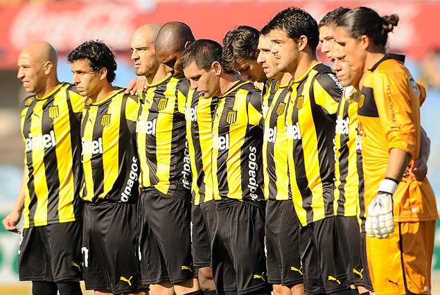 Los jugadores de Peñarol en el minuto de silencio por el taximetrista fallecido. 