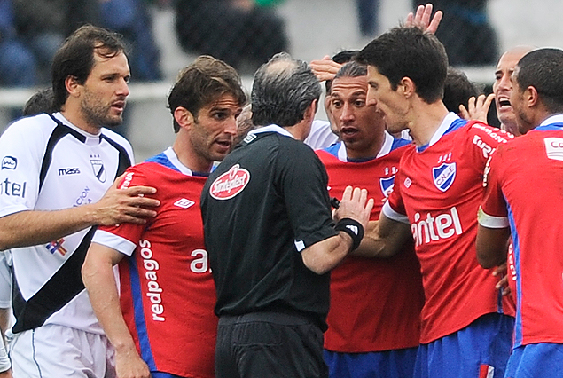 Iván Alonso en la protesta de los jugadores de Nacional, con Richard Porta y Alvaro Fernández, rodearon al árbitro Martín Vázquez.