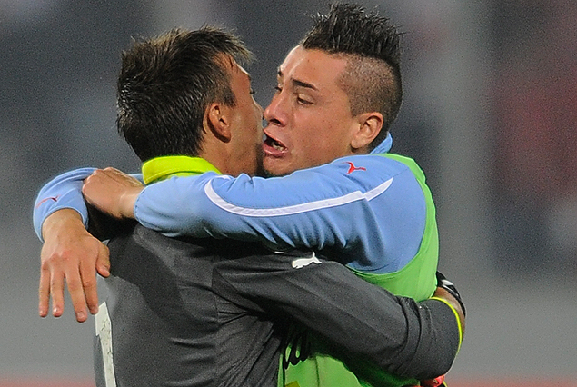 El apretado abrazo entre Fernando Muslera y José María Giménez, en la noche triunfal de Lima. El juvenil podría ser titular ante Colombia.