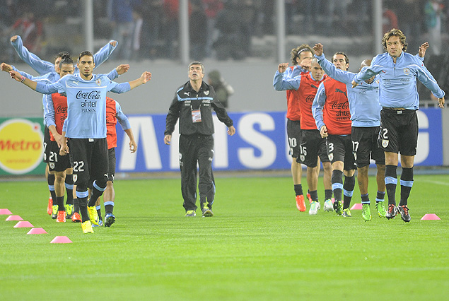 Los jugadores uruguayos calientan bajo la mirada del Profesor José Herrera.