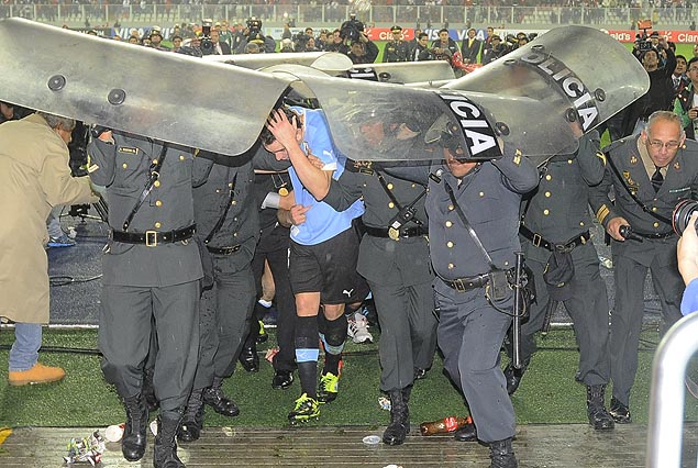 Diego Godín, bajo los escudos protectores de la policía camina rumbo a los vestuarios. 