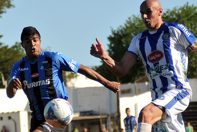 Rodrigo Aguirre busca escapar a la marca de Alejandro Acosta. 