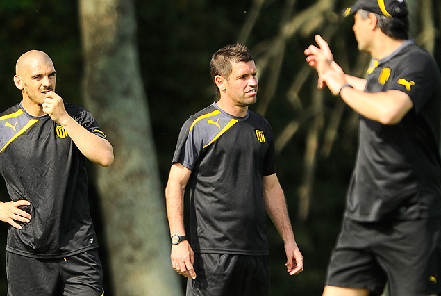 Damián Macaluso y el capitán Antonio Pacheco, escuchan atentamente las indicaciones del entrenador Jorge Goncalvez. 