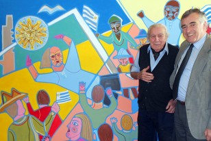 Carlos Páez Vilaró posa junto al mural que hoy se enviará al Complejo "Uruguay Celeste".