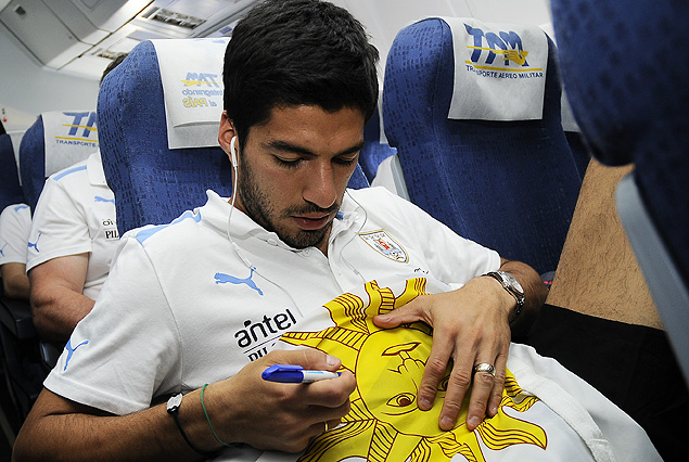 En pleno vuelo Suárez firma un autógrafo en una bandera uruguaya a pedido de un viajero.