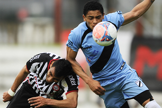 Jonathan Alvez busca escapar a la marca de Martín Cardozo.