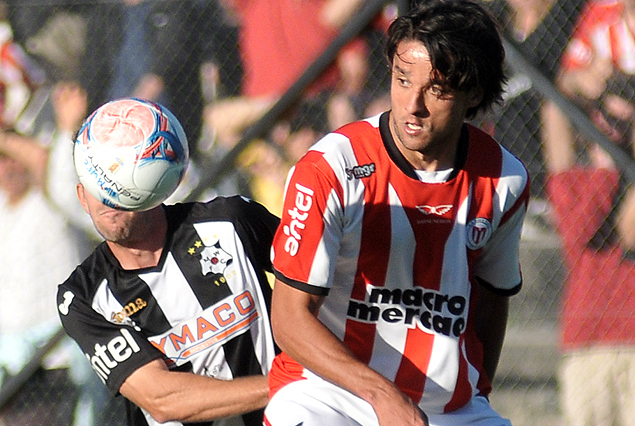 Diego Riolfo no llega y Gabriel Marques despeja el balón.