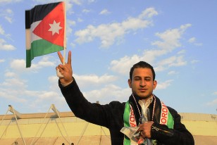 Un hincha de Jordania con su bandera y la bufanda del partido, en las afueras del Estadio captado esta tarde-noche de aquí.