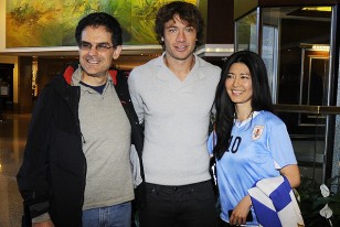 La pareja de los funcionarios del Banco Mundial, formada por un uruguayo y una japonesa, posan con Diego Lugano.