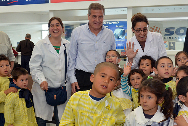 El Maestro Tabárez en el aeropuerto, posa junto a dos maestras y un grupo de escolares. 