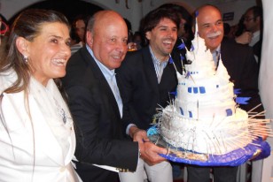 Agó y Josema sostienen la torta de cumpleaños que representaba Casapiueblo, junto con uno de los nietosde Carlos y un amigo.