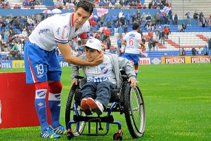 Andrés Scotti junto al pequeño Fabricio, en la silla deportiva que le obsequiaron los jugadores tricolores.