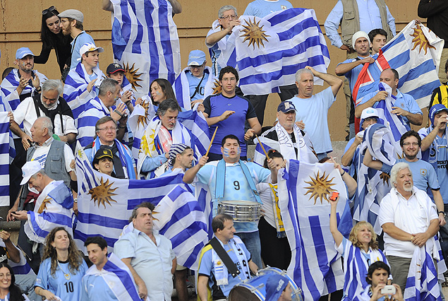 Compatriotas con sus banderas en la tribuna principal del estadio.