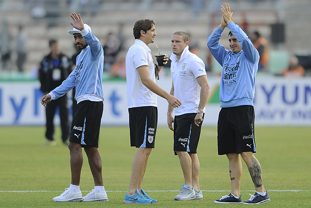 Los jugadores uruguayos en la cancha saludan a  compatriotas en la tribuna.