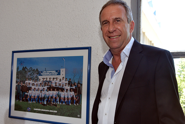 Gerardo Pelusso en la sede, posando junto al cuadro del plantel Campeón Uruguayo que dirigió en la temporada 2008-2009.