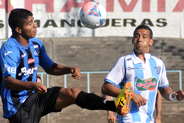Rodrigo Aguirre y Javier Méndez van en busca del balón.