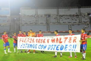 Los jugadores de Nacional con la pancarta en apoyo de Walter Ferreira y la señora "Yaya".