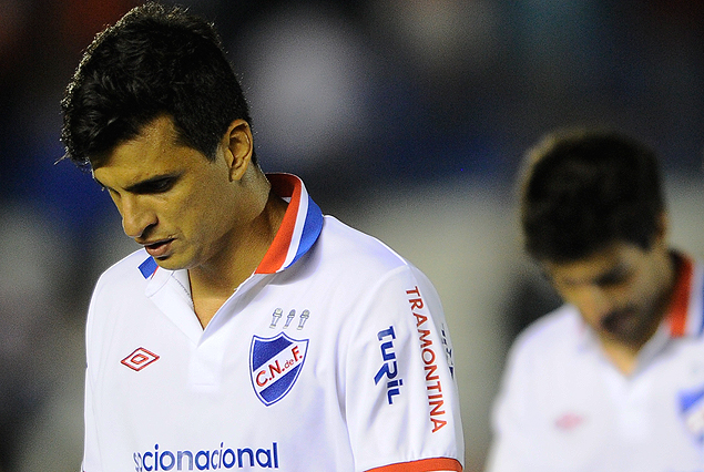 Jorge Curbelo y Juan Manuel Díaz, cabeza baja, son la imagen de la derrota. Nacional cayó sin levante en Rosario. 