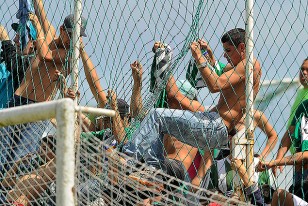 Hinchas de Racing trepados al tejido. ¿Por qué se demora tanto la participación policia. Prevención que le llaman. 