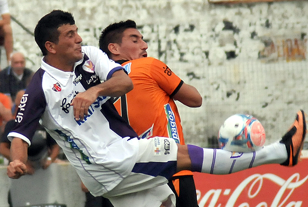Aníbal Hernández busca el balón, Angel Luna llega a su marca.