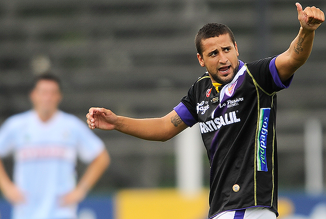 Maximiliano Callorda festeja el segundo de Fénix, en el fondo la silueta de Díaz sufriendo el resultado. 