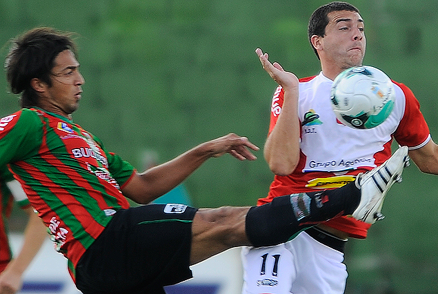 Alejandro Rodríguez intenta rechazar el balón ante la presencia amenazante de Gastón Colman.