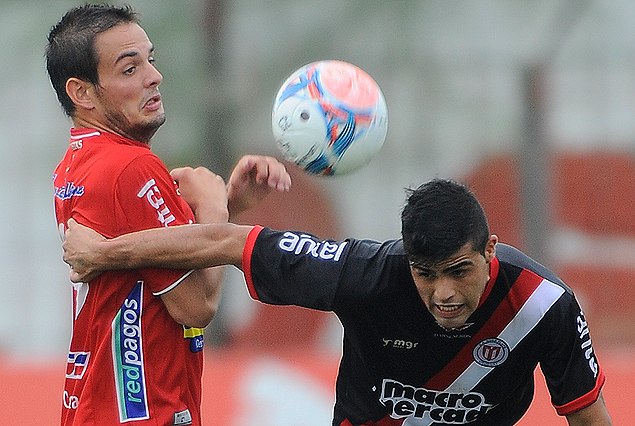 Martín Alaniz corre hacia el balón, con Octavio Rivero intentando la marca.