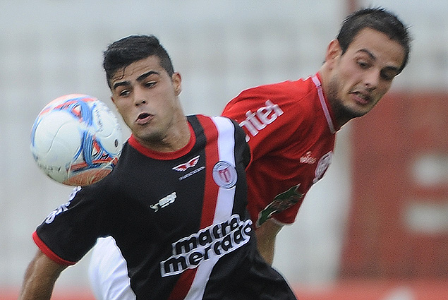 Martín Alaniz corre con la mirada fija en el balón, Octavio Rivero queda atrás.