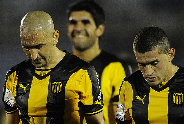 Sergio Orteman y Mauro Fernández se marchan cabeza gacha de la cancha. Javier Toledo en el fondo es puro lamento.