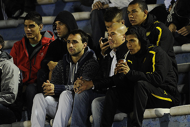 El peruano Paolo Hurtado y Emiliano Albin en el grupo de jugadores de Peñarol que siguieron el partido en la Tribuna América.