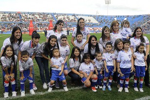 Las madres tricolores posan junto a sus hijos en el campo de juego del Gran Parque Central.